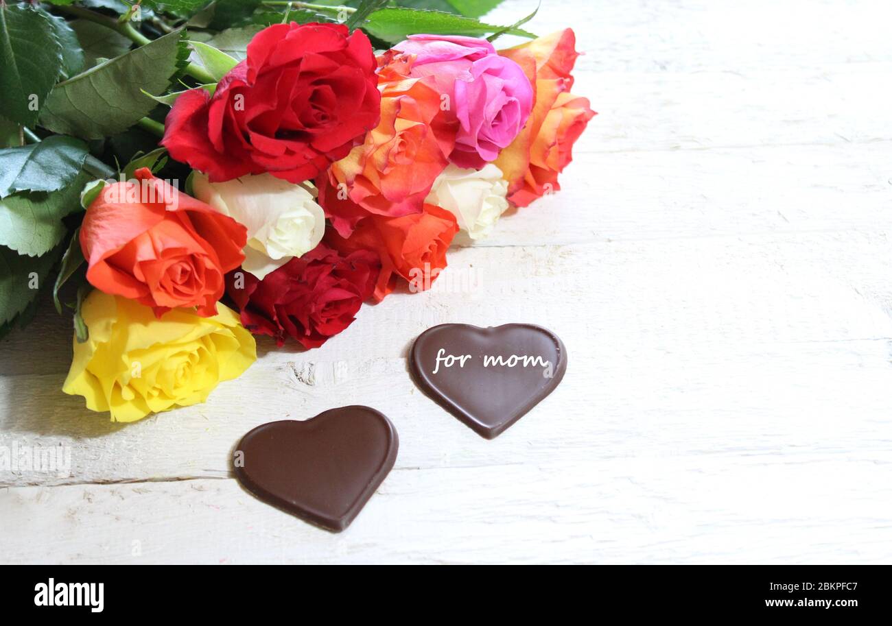 The picture shows colourful roses and chocolate hearts for mother`s day